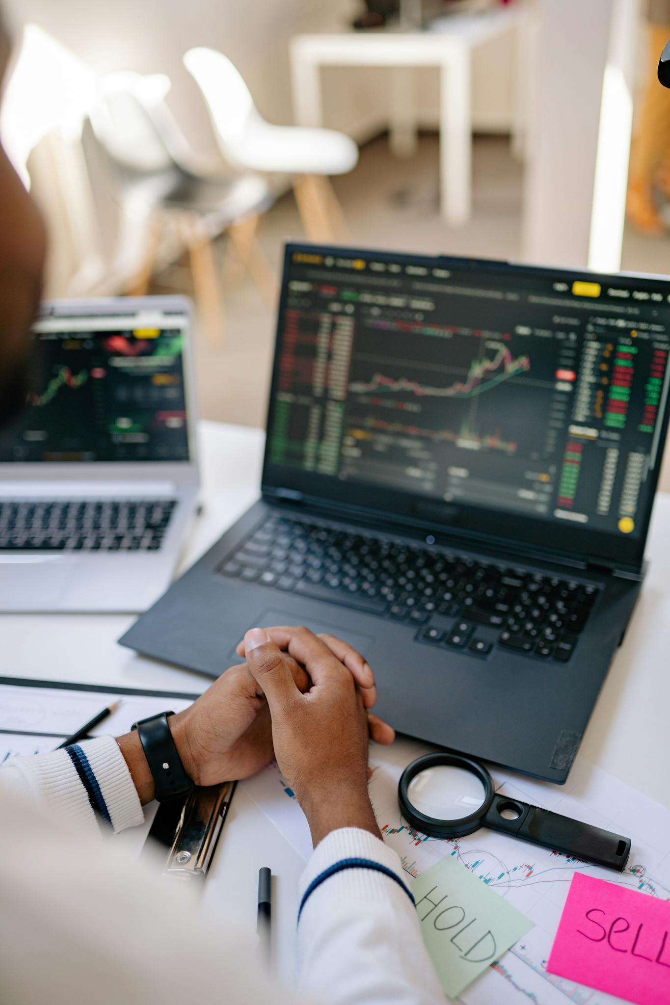 Person analyzing stock market trends on a laptop in an office setting.